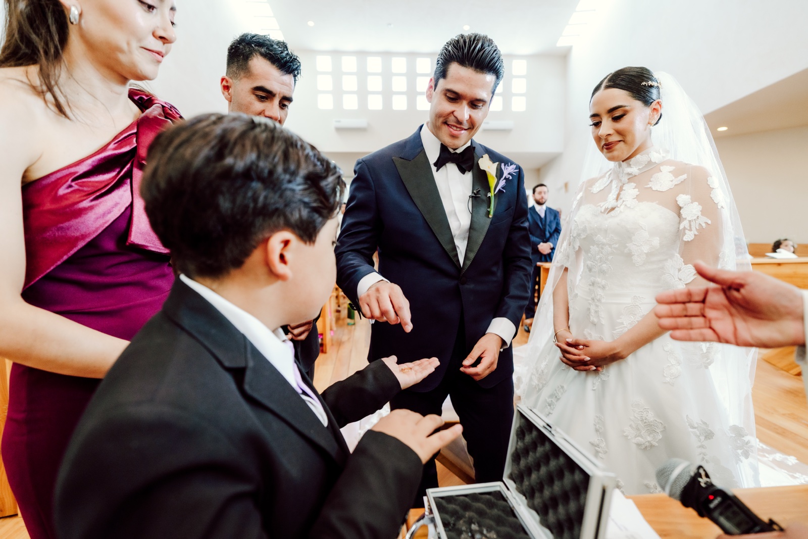 novios rodeados de acompañantes junto al altar