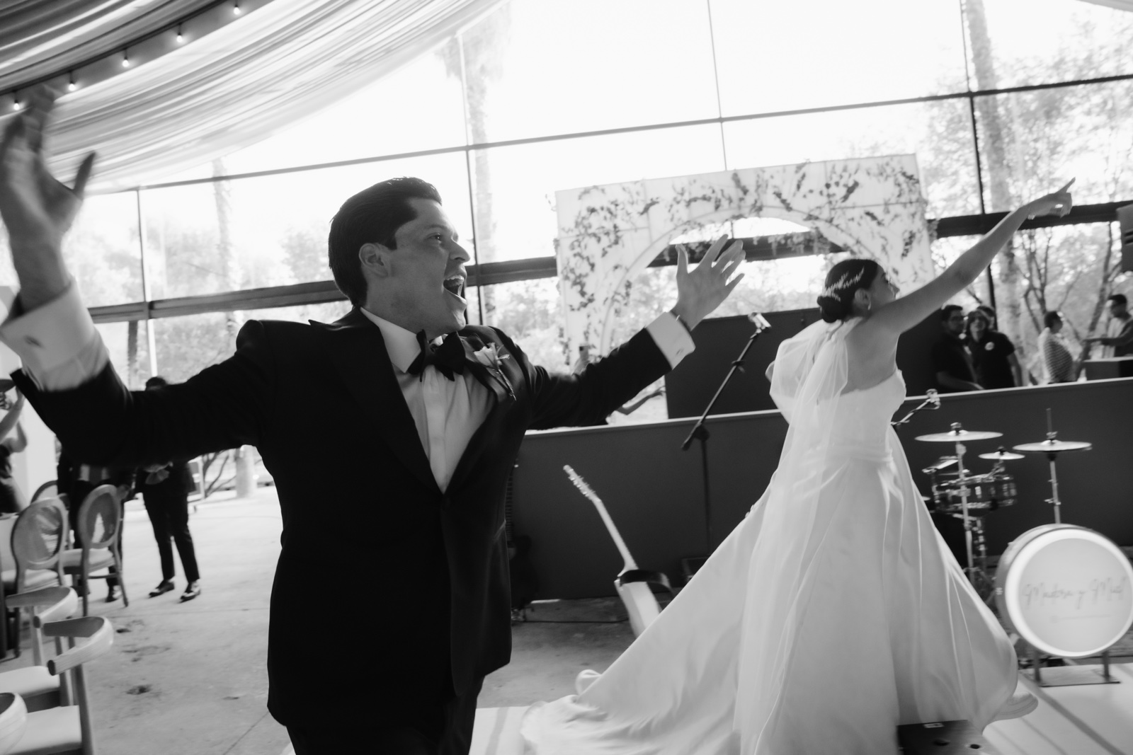 novios entrando con los brazos abiertos, en blanco y negro