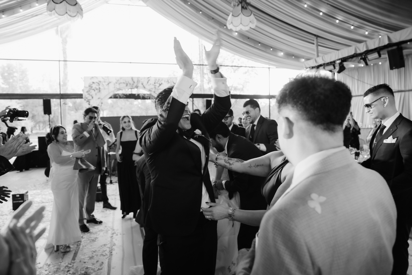 novio entre sus invitados en la recepción, en blanco y negro