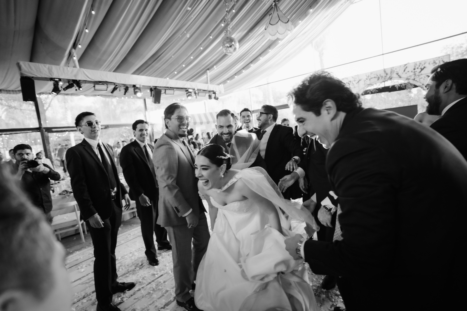 novios junto a sus invitados en la recepción, en blanco y negro