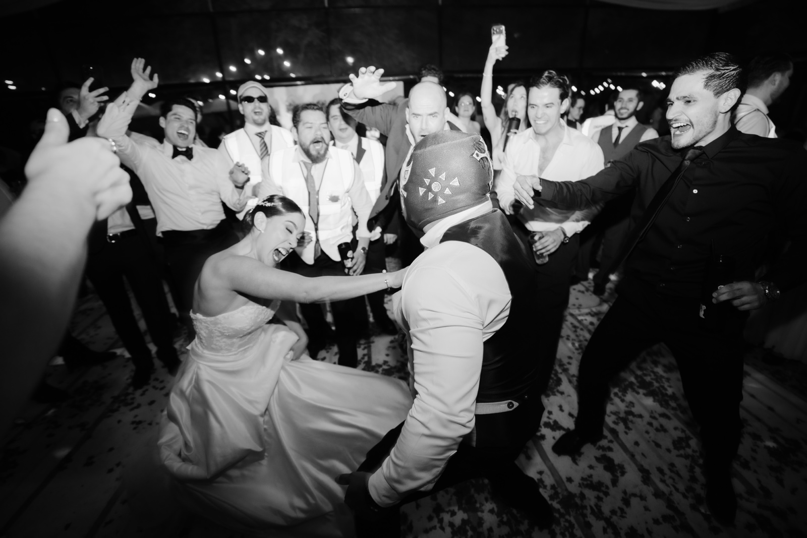 invitados abrazados durante la fiesta, en blanco y negro
