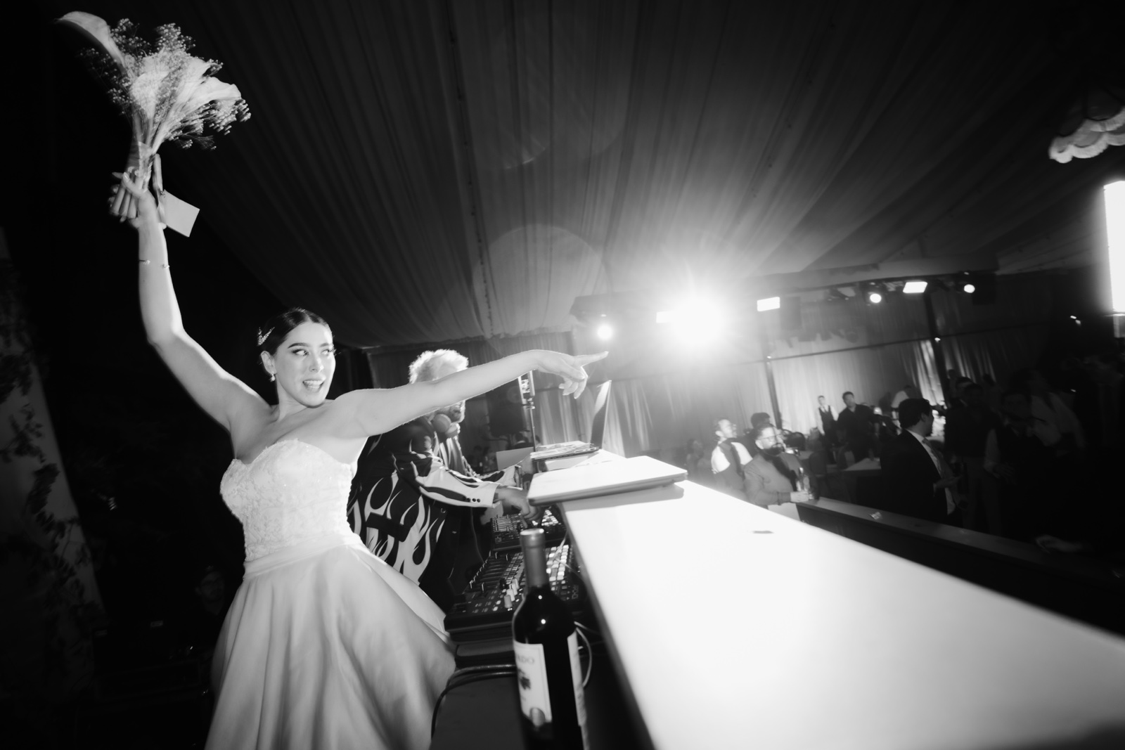 novia sosteniendo su ramo en alto, en blanco y negro