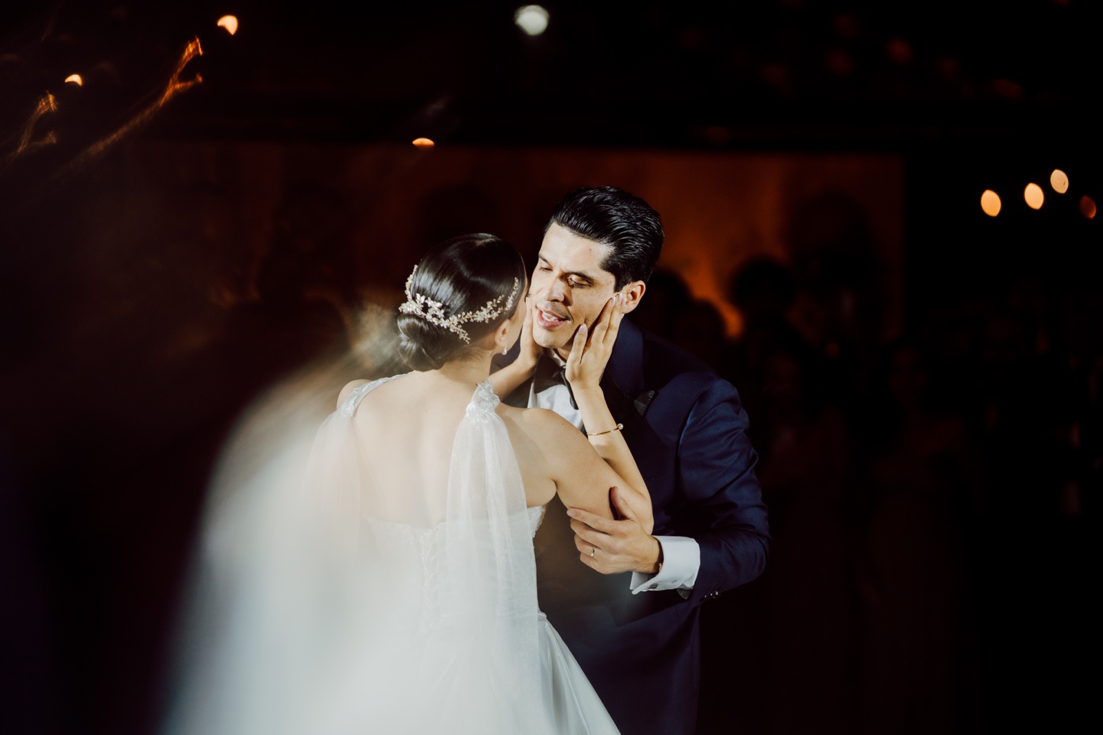 novios abrazados bajo las luces de la pista