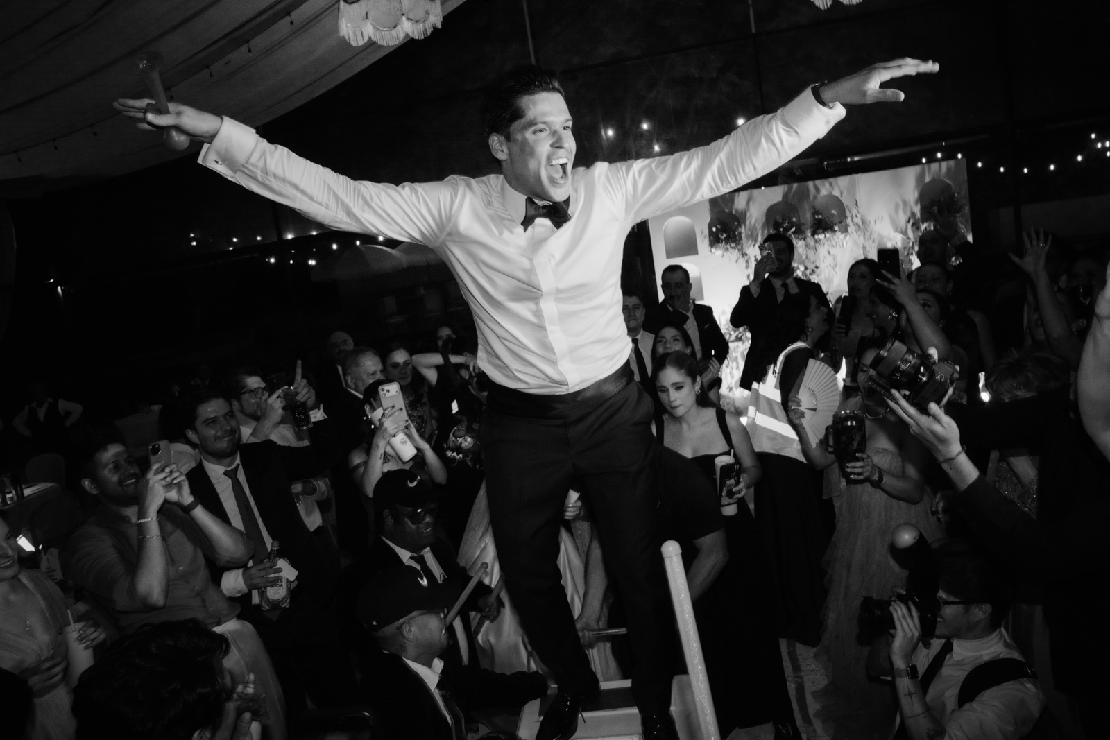 invitado levantado por sus amigos, en blanco y negro