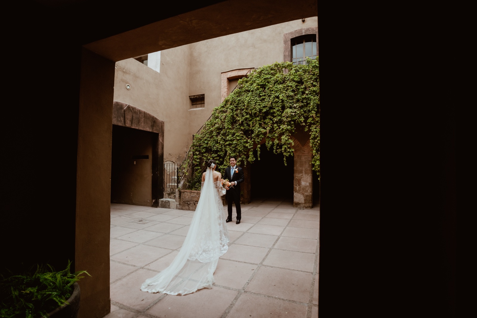 novia vista desde una puerta en sombra hacia el patio