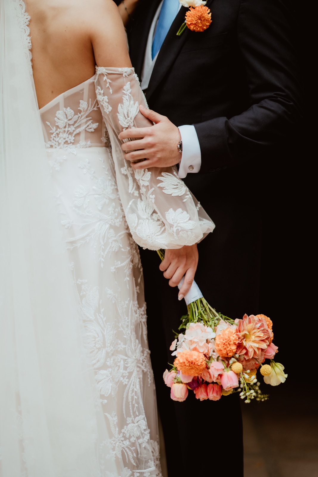 detalle de los novios tomados del brazo y del ramo