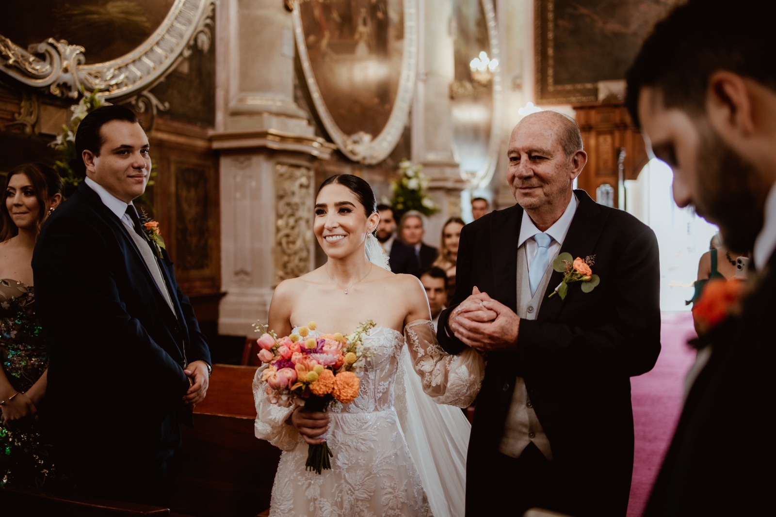 novia acompañada hacia el altar con su ramo