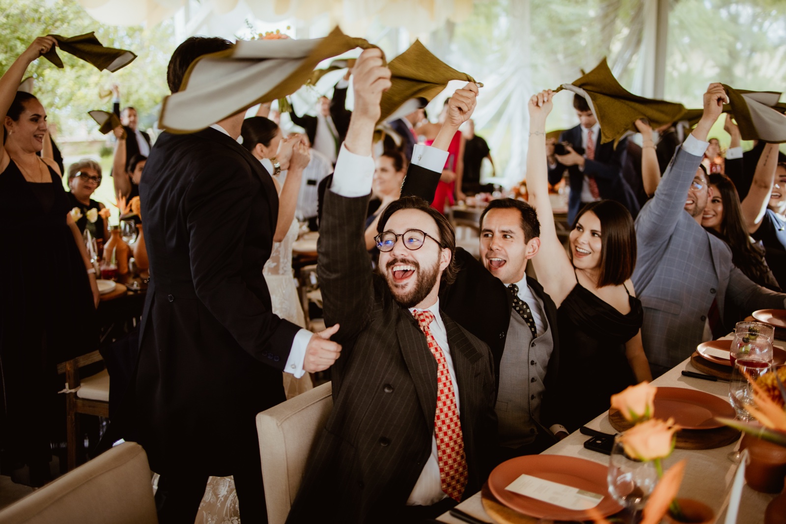 invitados con los brazos levantados en la recepción
