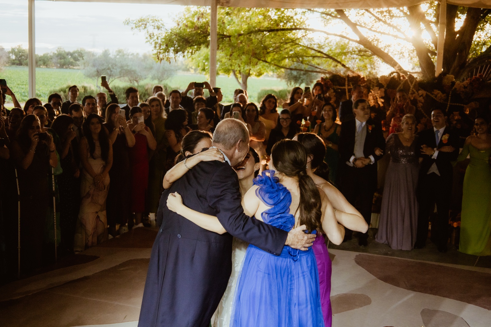 pareja abrazada mientras los invitados observan