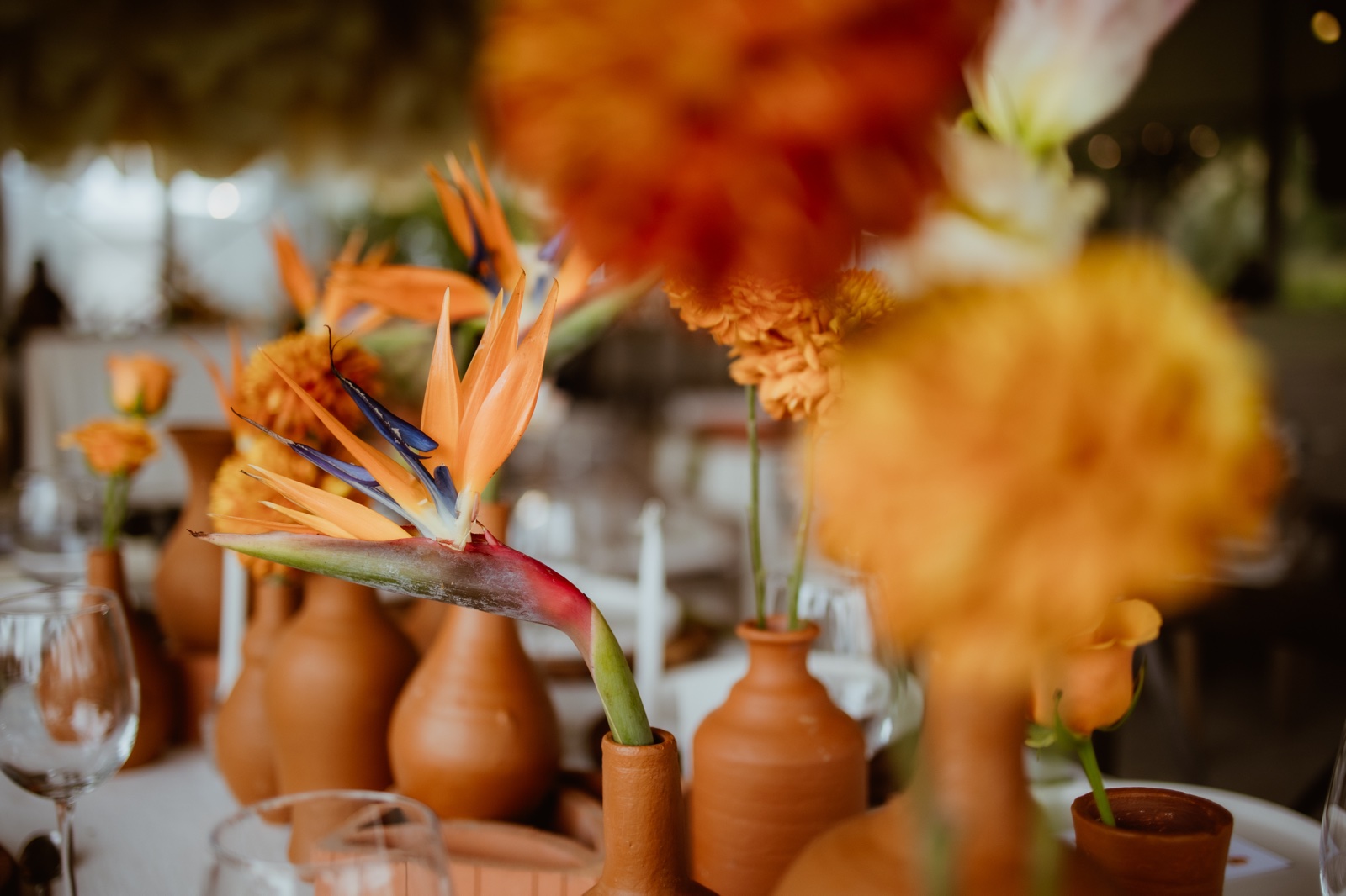 arreglo de flores naranjas y copas de la recepción