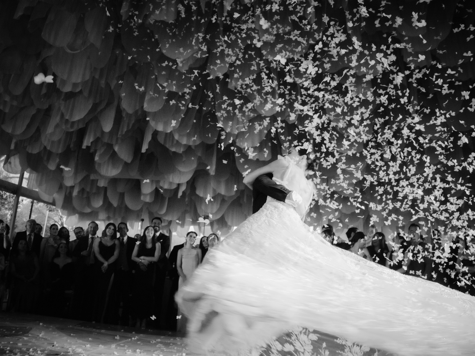vestido y velo de novia en movimiento bajo confeti, en blanco y negro