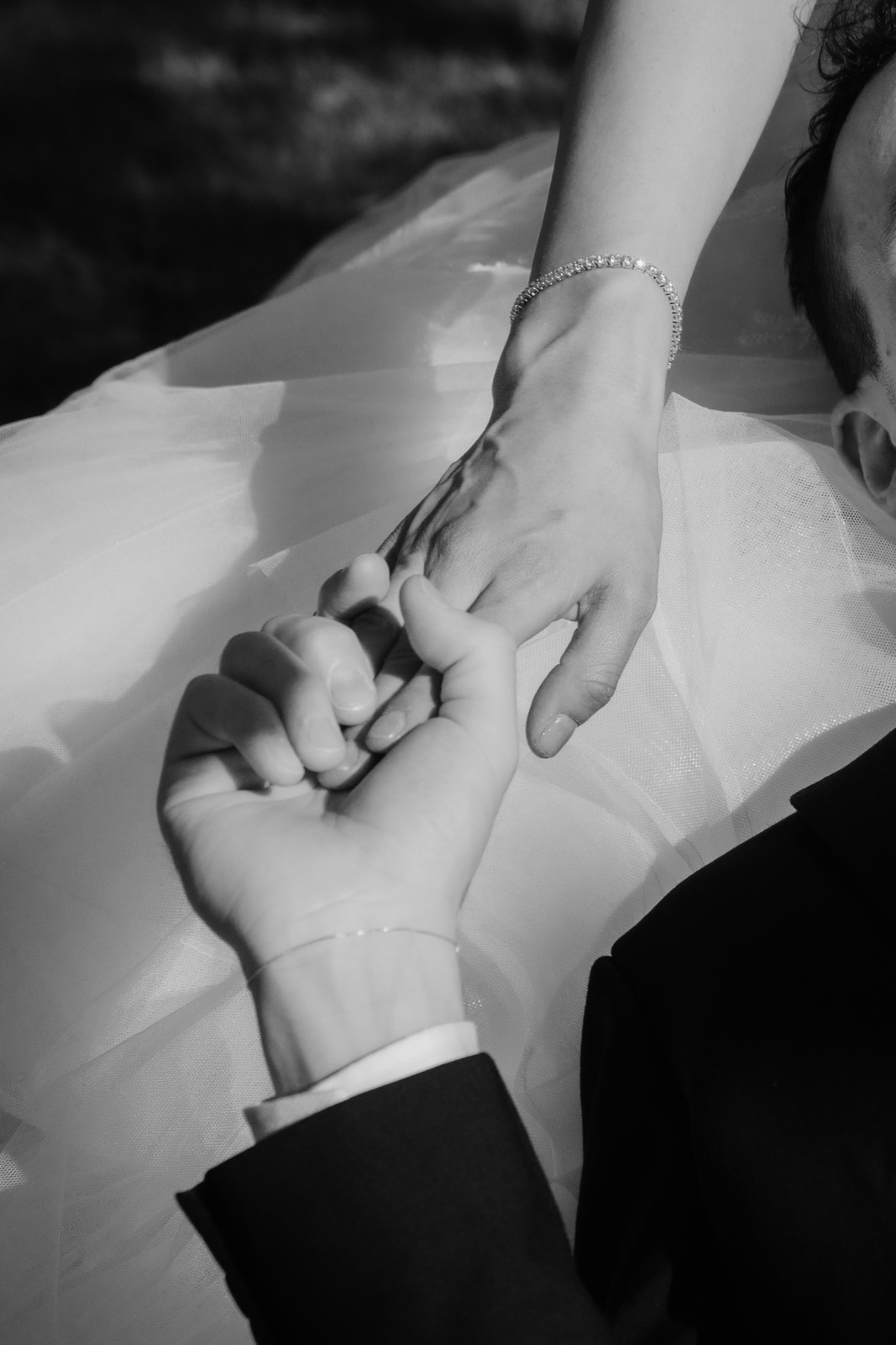 detalle de las manos de los novios juntas, en blanco y negro