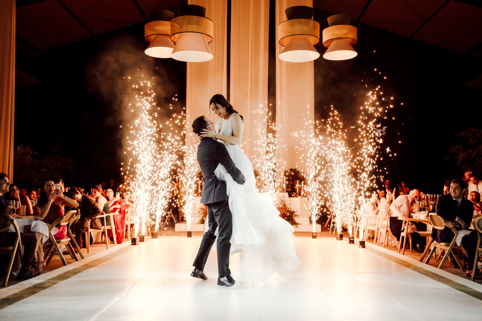 novios abrazados entre columnas de chispas luminosas