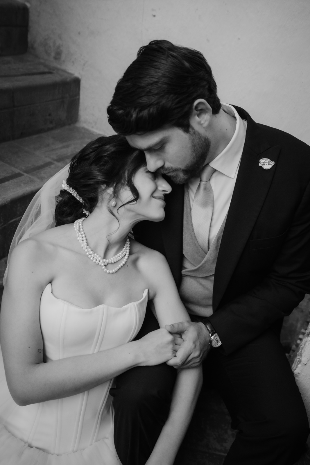 novios mirando sus manos juntas, en blanco y negro