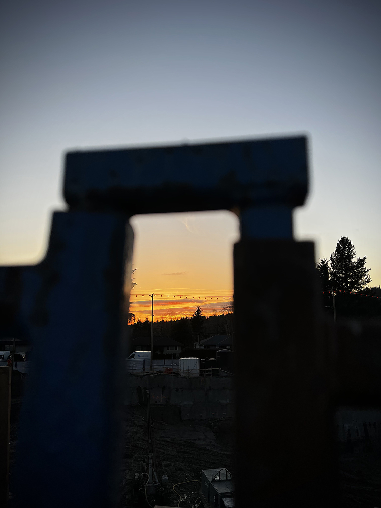 Silhouette of a stone gateway against a glowing orange sunset