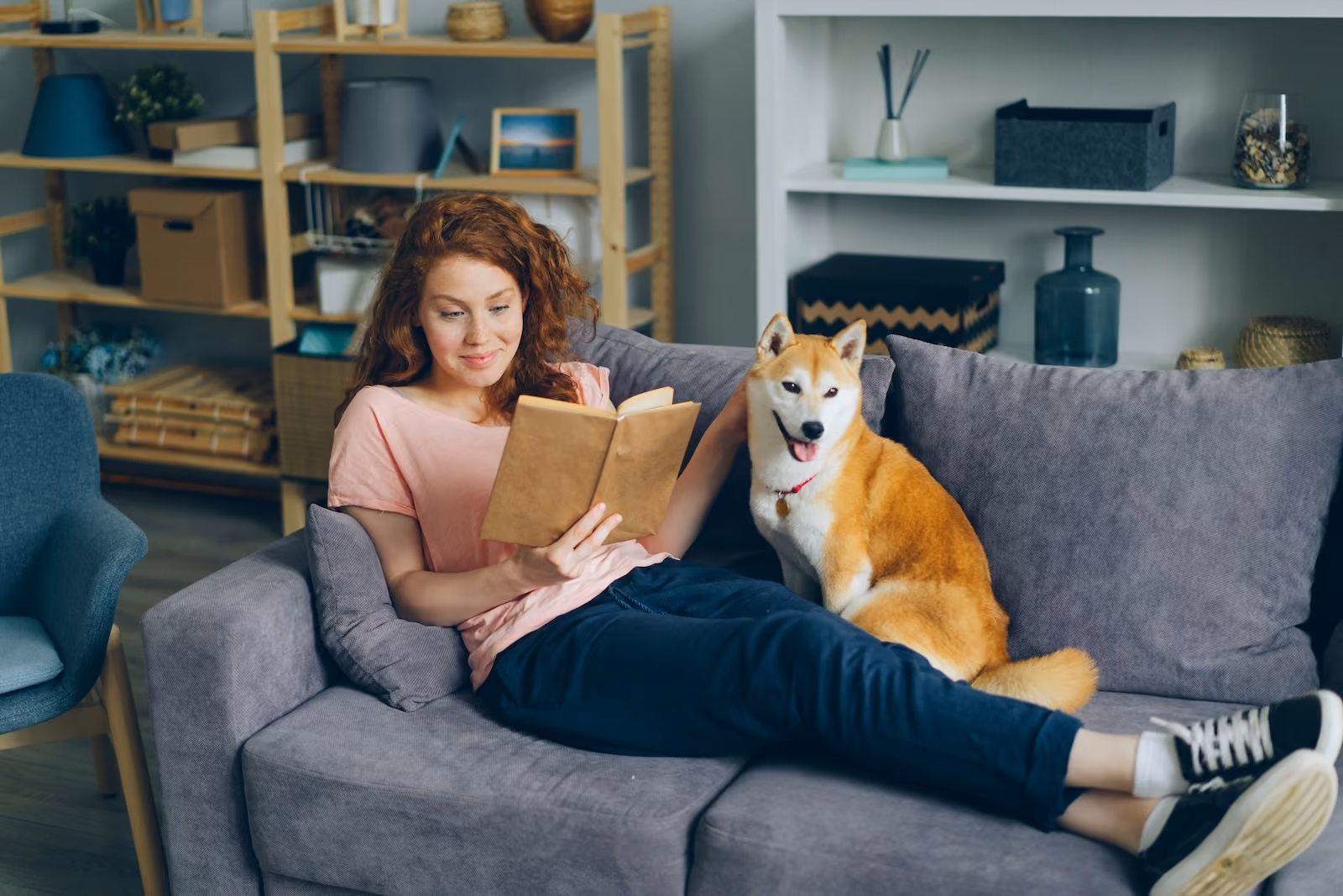 Woman reading on the couch with dog