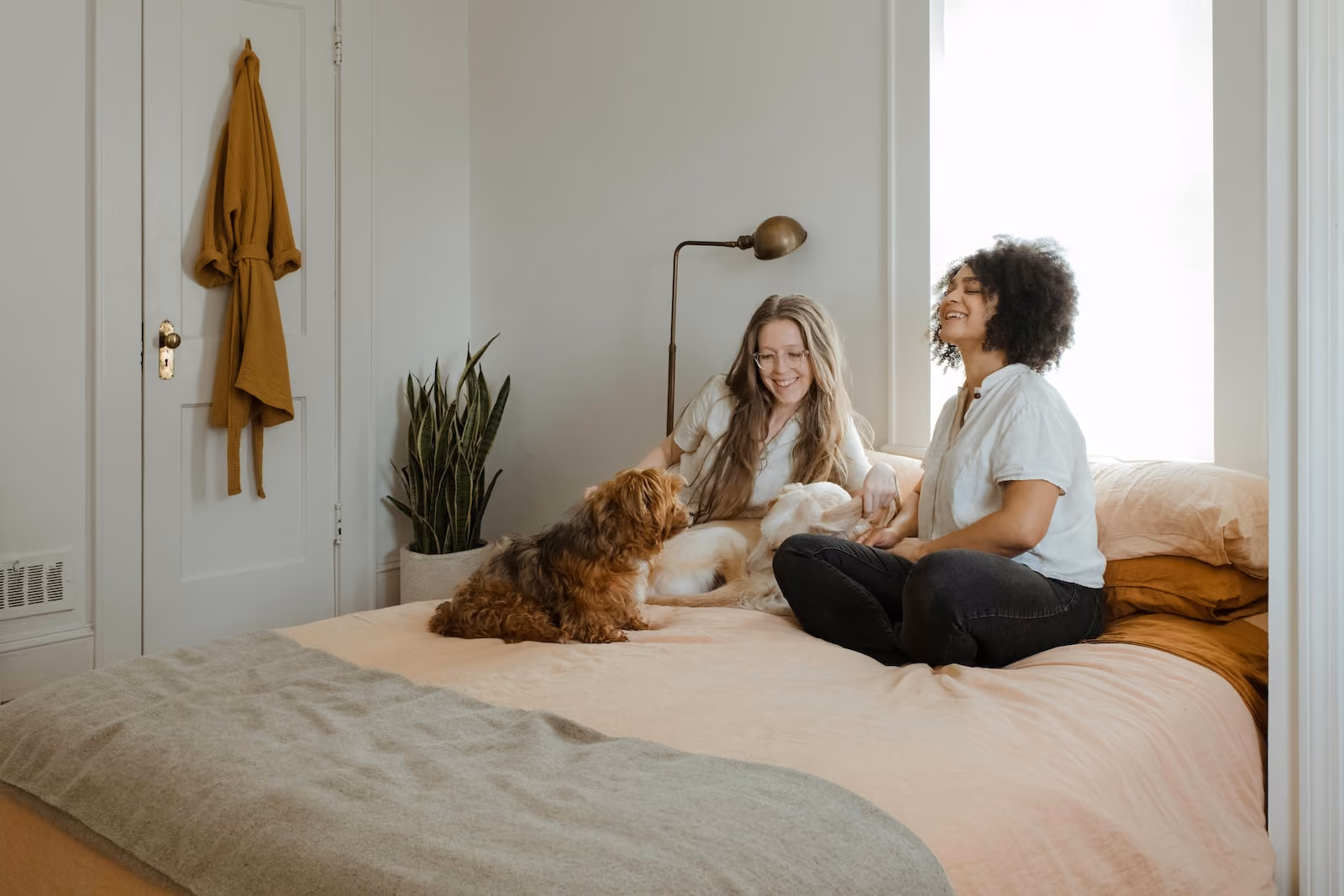 Two people sitting on bed with dog
