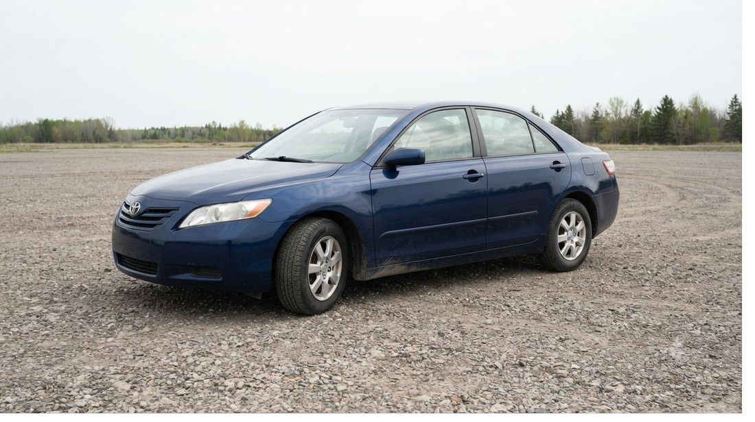 Sedan parked in a gravel storage lot
