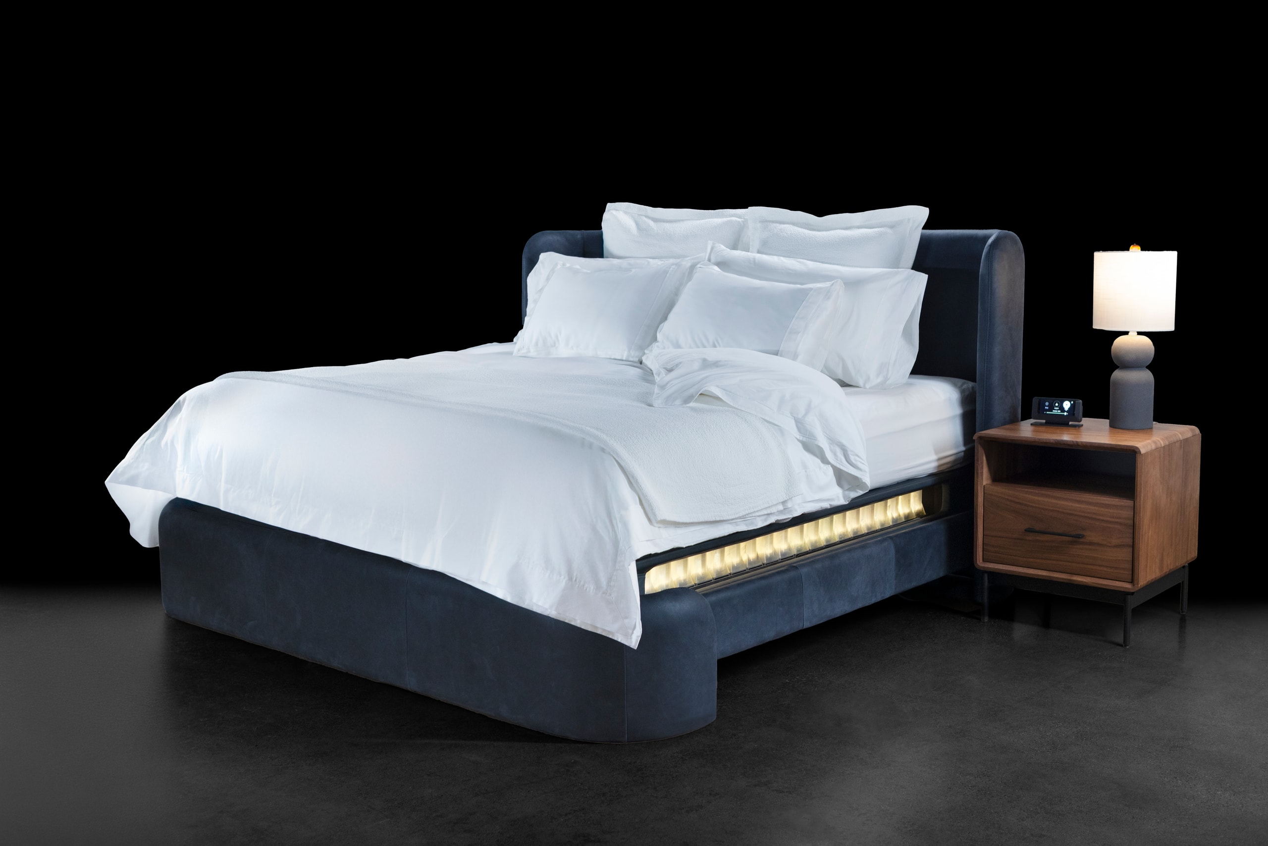 The Sleep System dressed in white linen with a navy surround and a walnut bedside table