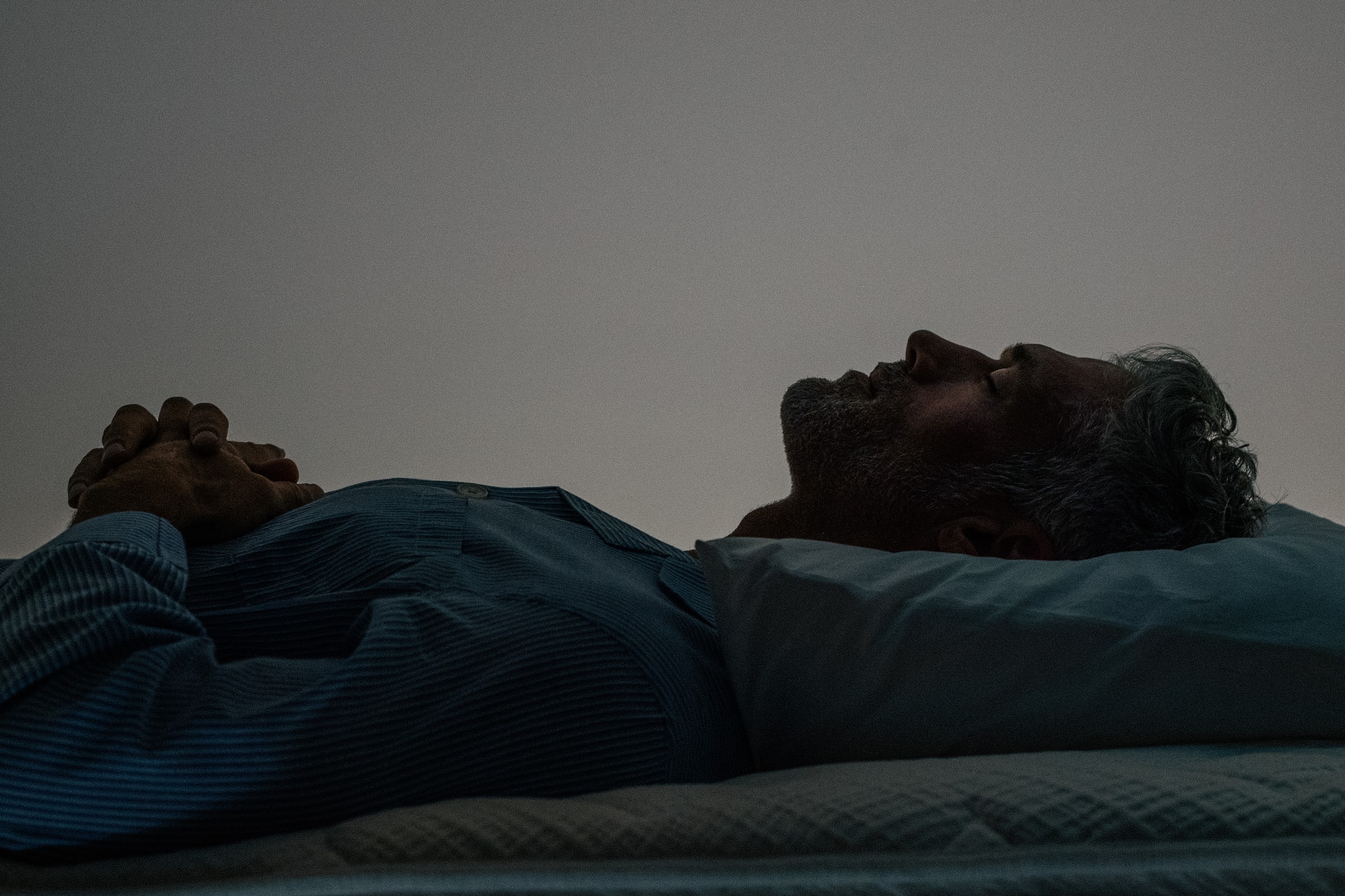 A sleeper on their back on the Sleep System, seen along the length of the bed
