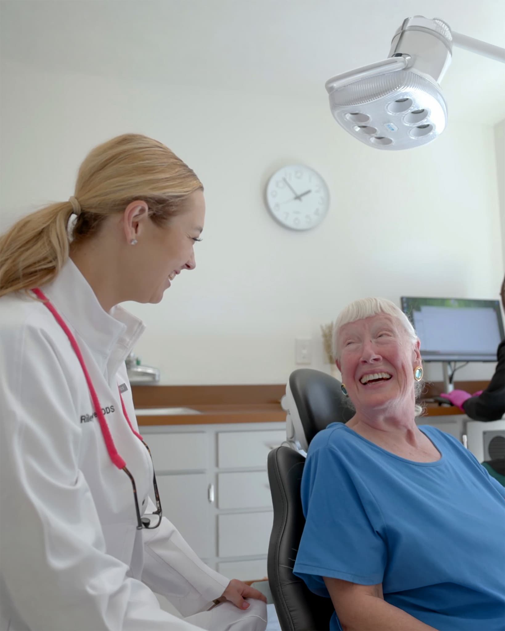 Smiling patient in the dental chair talking with Dr. Riley Oliver, dentist in Sonoma, CA