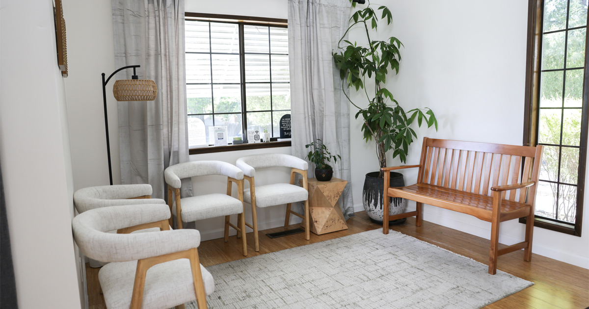 Waiting room at Sonoma Springs Dental, a boutique dentist in Sonoma, CA, with cushioned chairs and a wooden bench