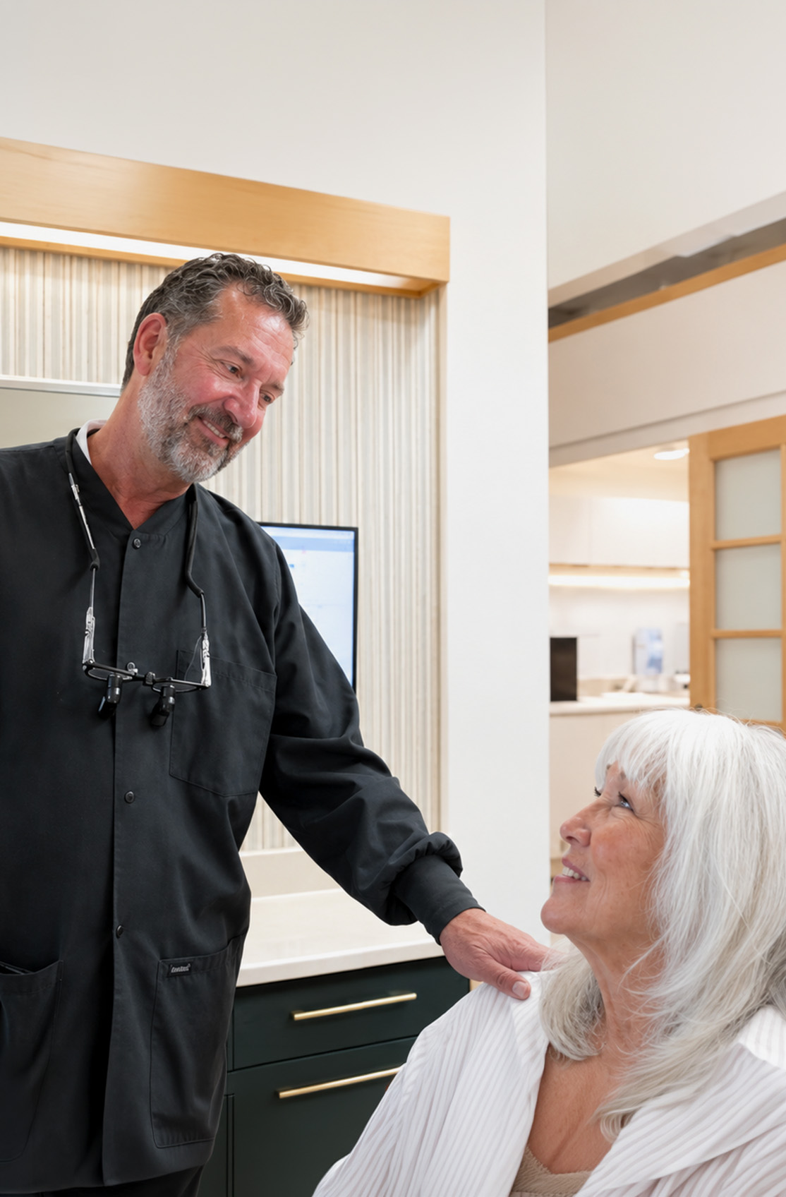 Dr. Kenneth J. Bevan chatting with a smiling patient at Bevan Dental, a gentle dentist in Napa, CA