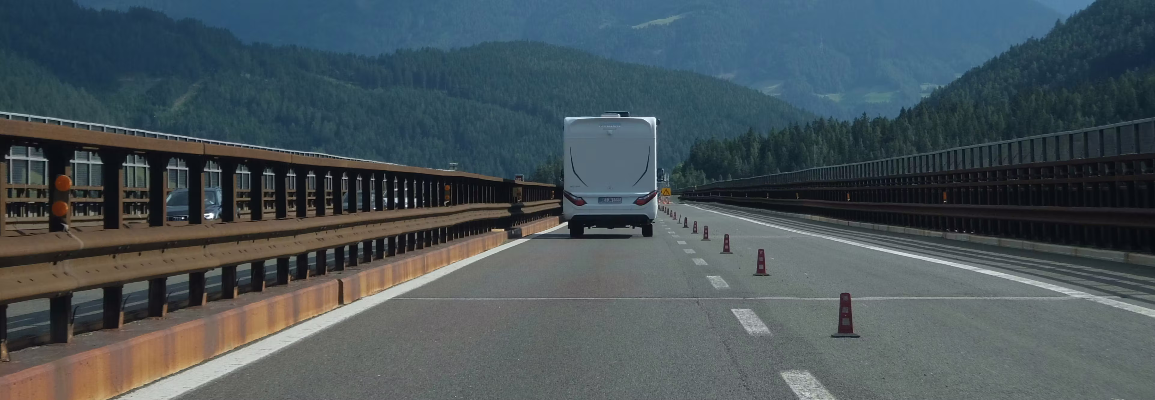 Box truck crossing a mountain bridge road