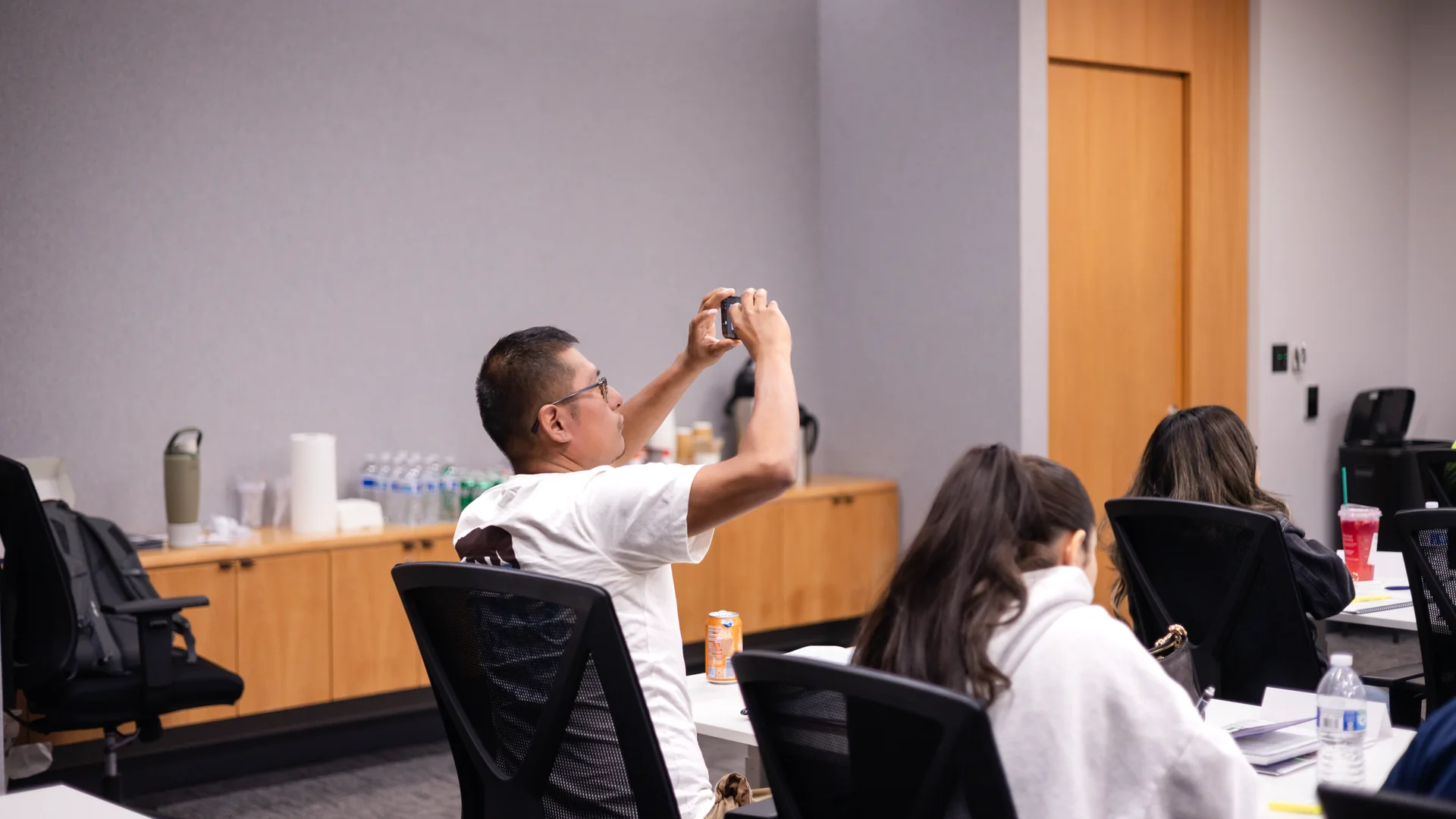 Student taking a photo of the lesson during a public adjuster exam prep class