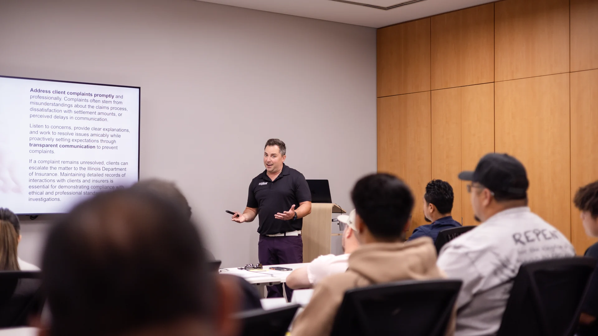 Instructor leading a live public adjuster exam prep class in front of a room of students