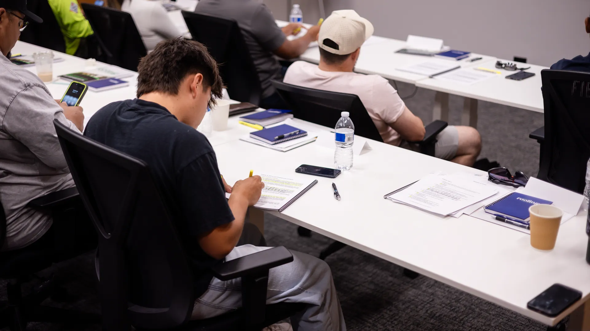 Students highlighting their public adjuster course workbooks during class
