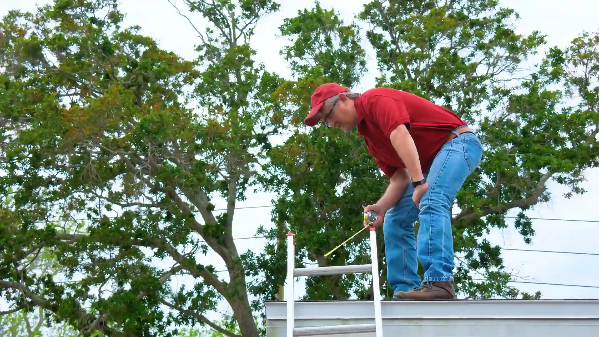 Public adjuster on a ladder inspecting a roof