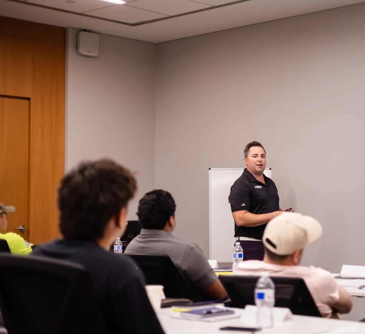 Instructor at the front of the room walking a class through a public adjuster lesson