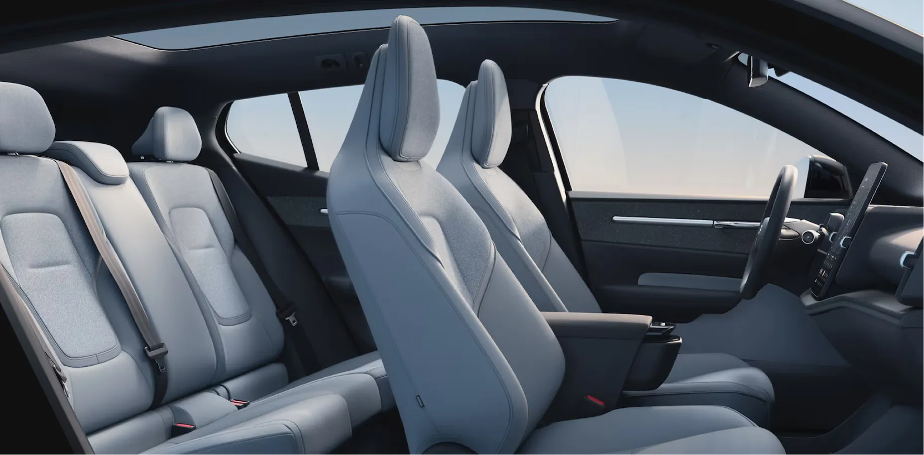 Modern interior cabin view of a Volvo electric SUV featuring light blue wool blend seats and a panoramic glass roof.