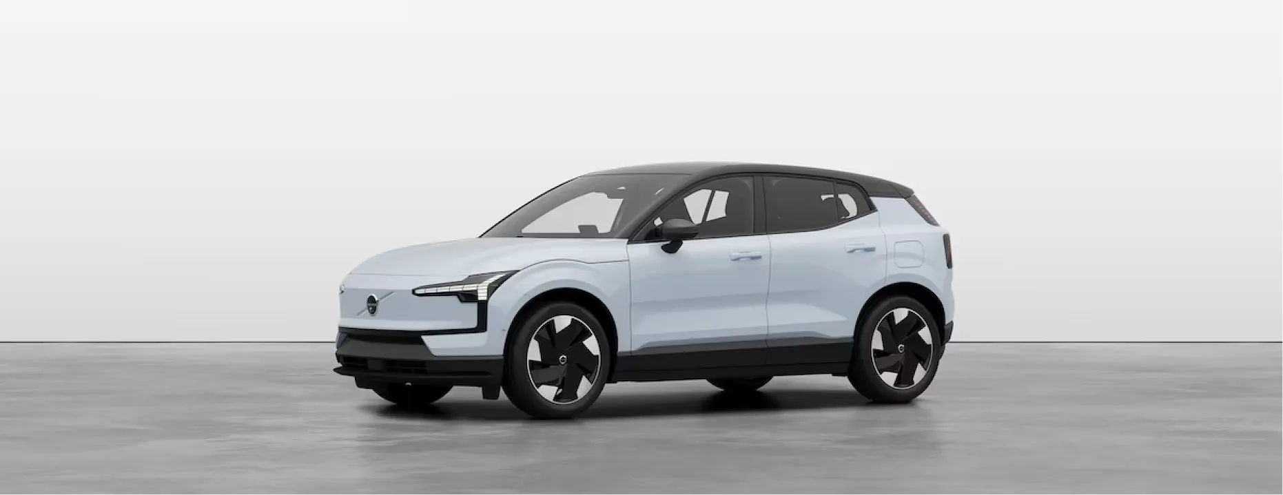 Side profile of a light blue electric Volvo EX30 compact SUV with a black contrast roof and aero alloy wheels.