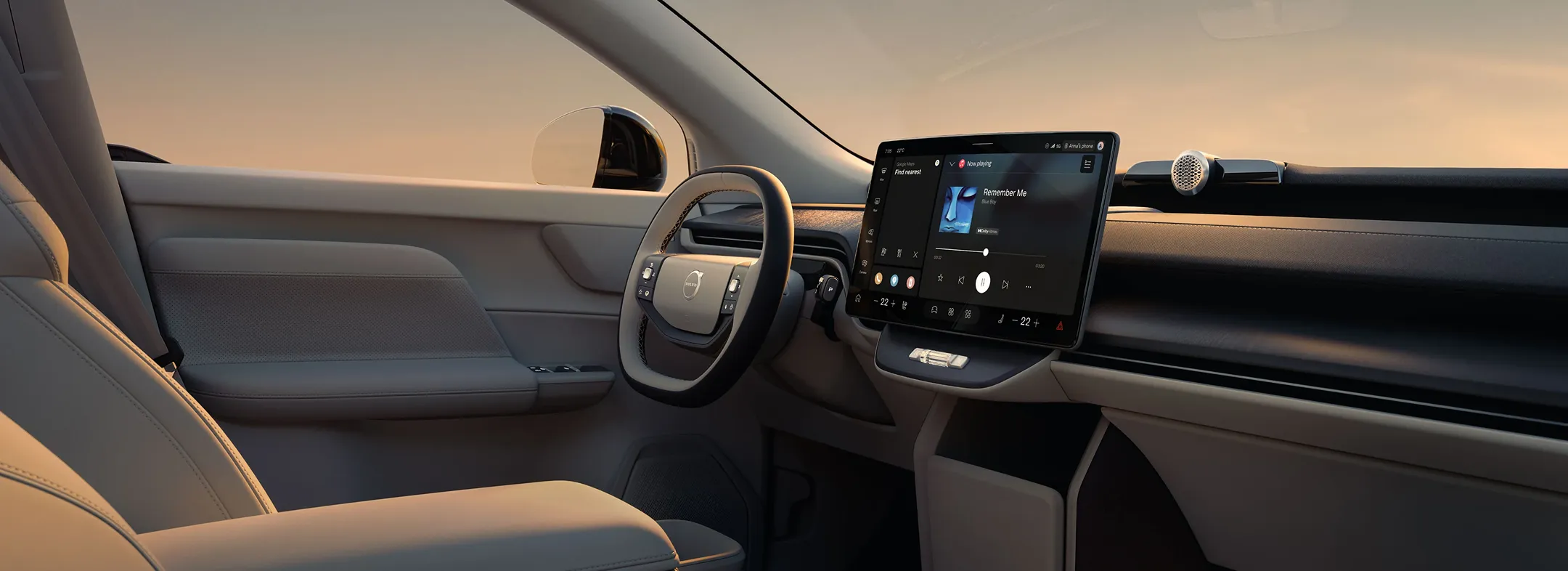 Volvo dashboard showing two-tone squared steering wheel, center touchscreen display, and Harman Kardon soundbar.