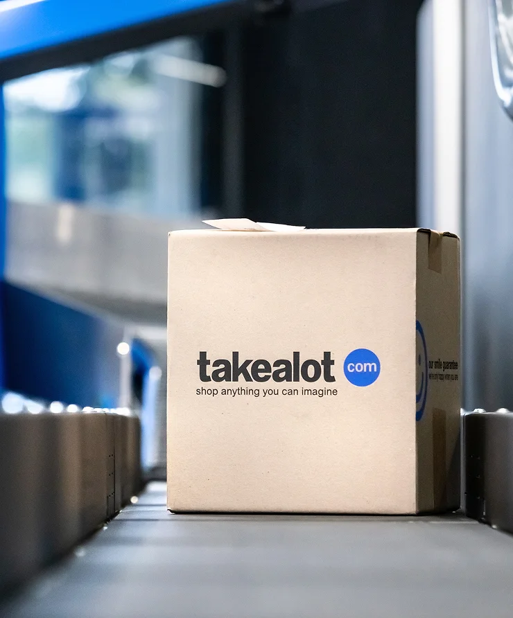 Takealot branded cardboard package box moving on a conveyor belt in a fulfillment warehouse
