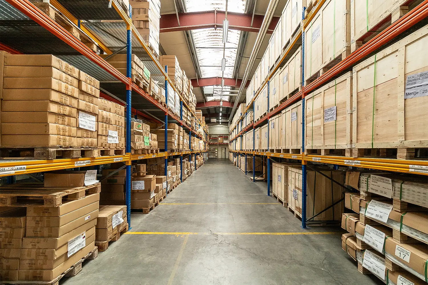 Lagergasse zwischen Palettenregalen mit palettierten Kartons in einer Logistikhalle