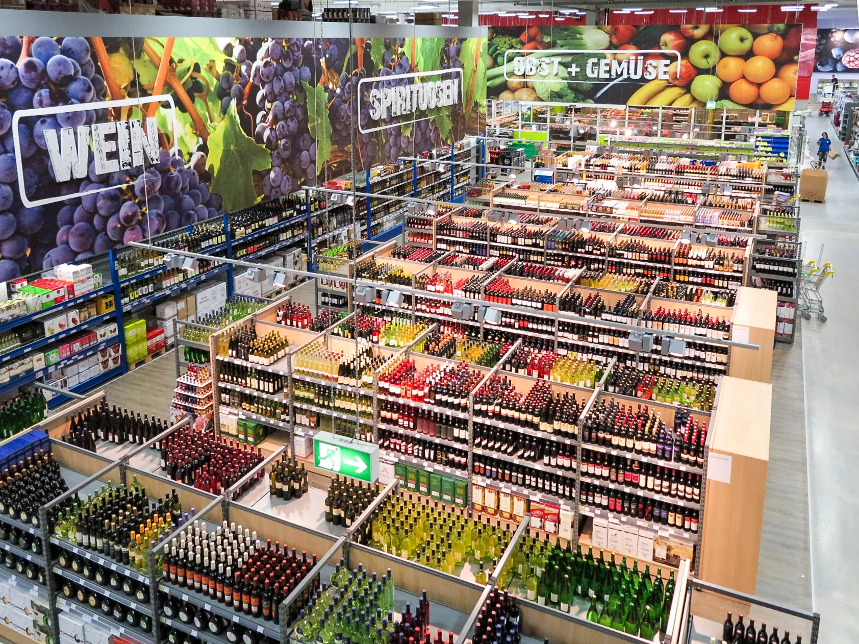 Blick von oben auf die Getränkeabteilung eines Cash-&-Carry-Markts mit Wein- und Spirituosenregalen