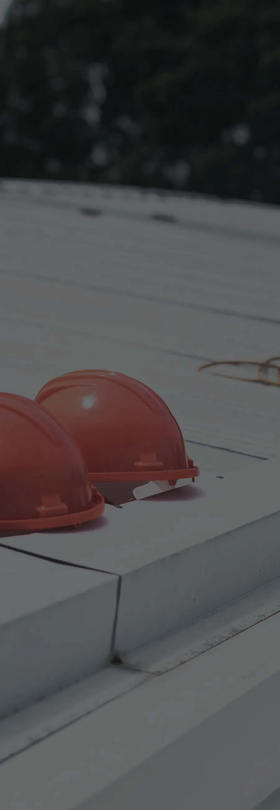 Orange safety helmets on an industrial rooftop