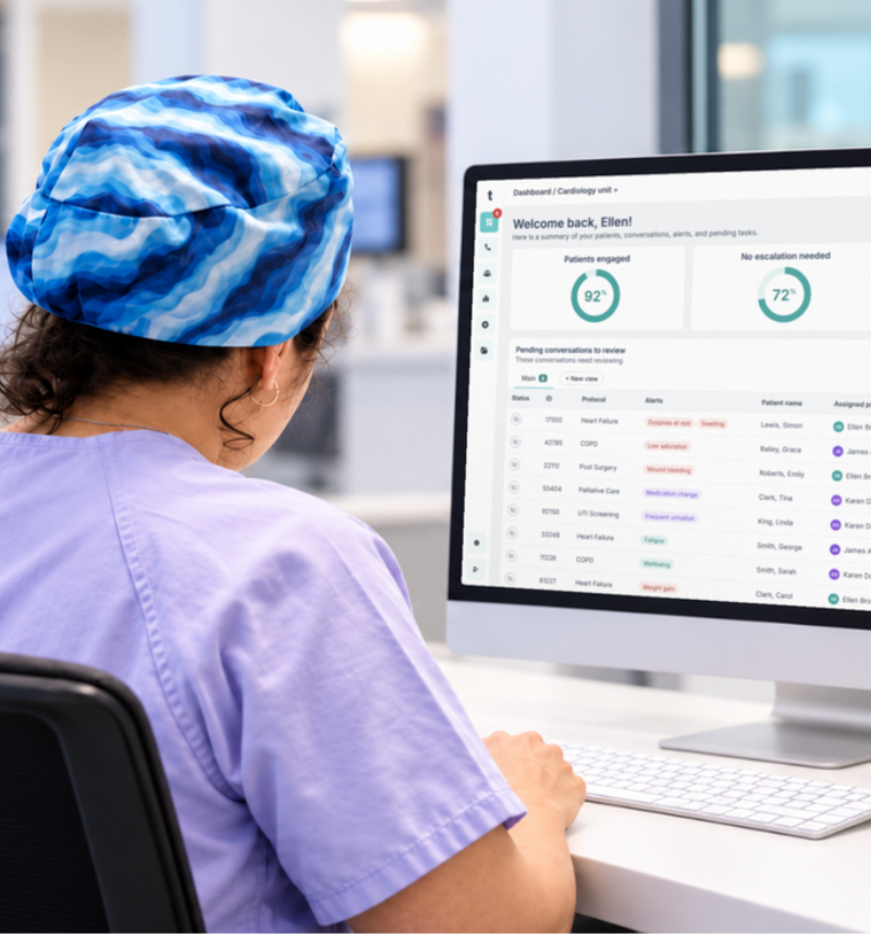 Nurse reviewing patient monitors at a hospital control desk