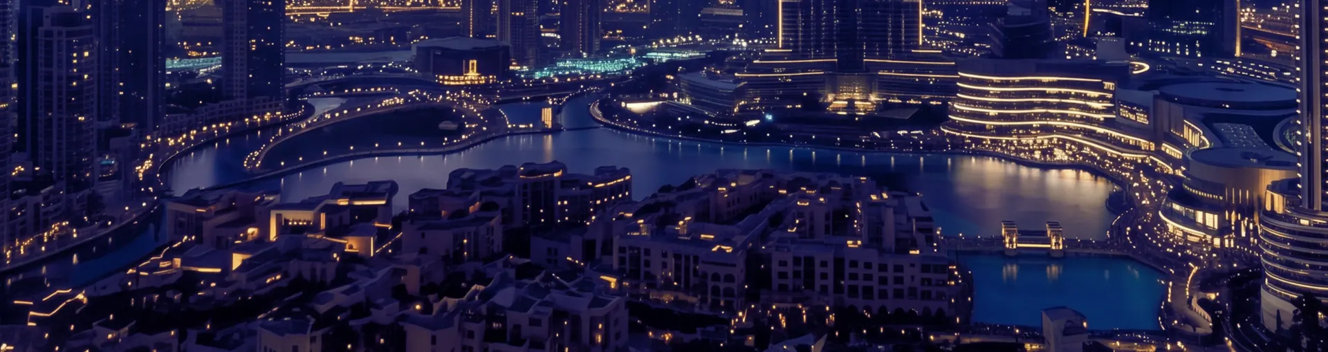 The Dubai Fountain lake at night, ringed by lit towers