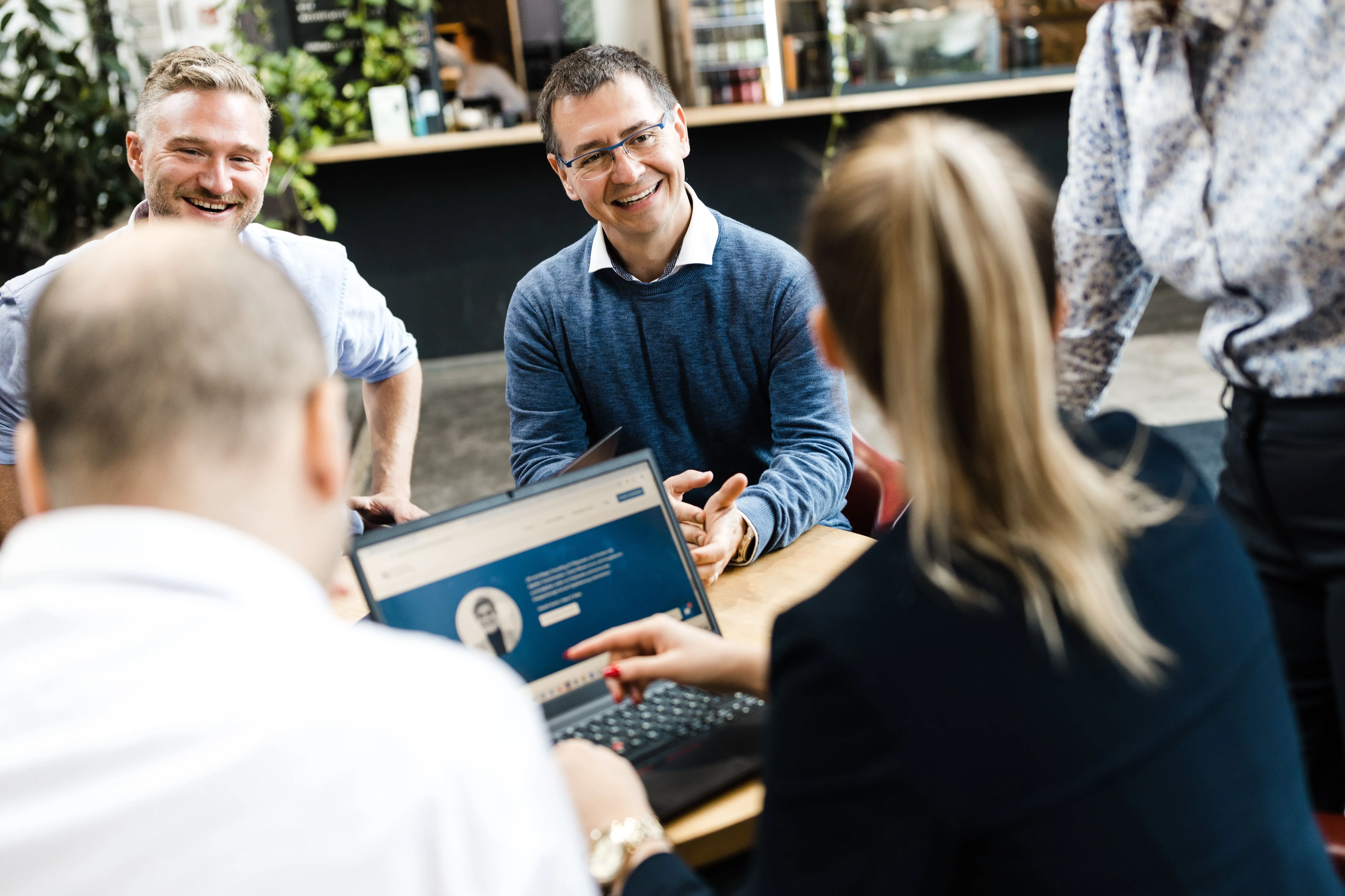 Lachende Mitarbeitende von Mages Consulting