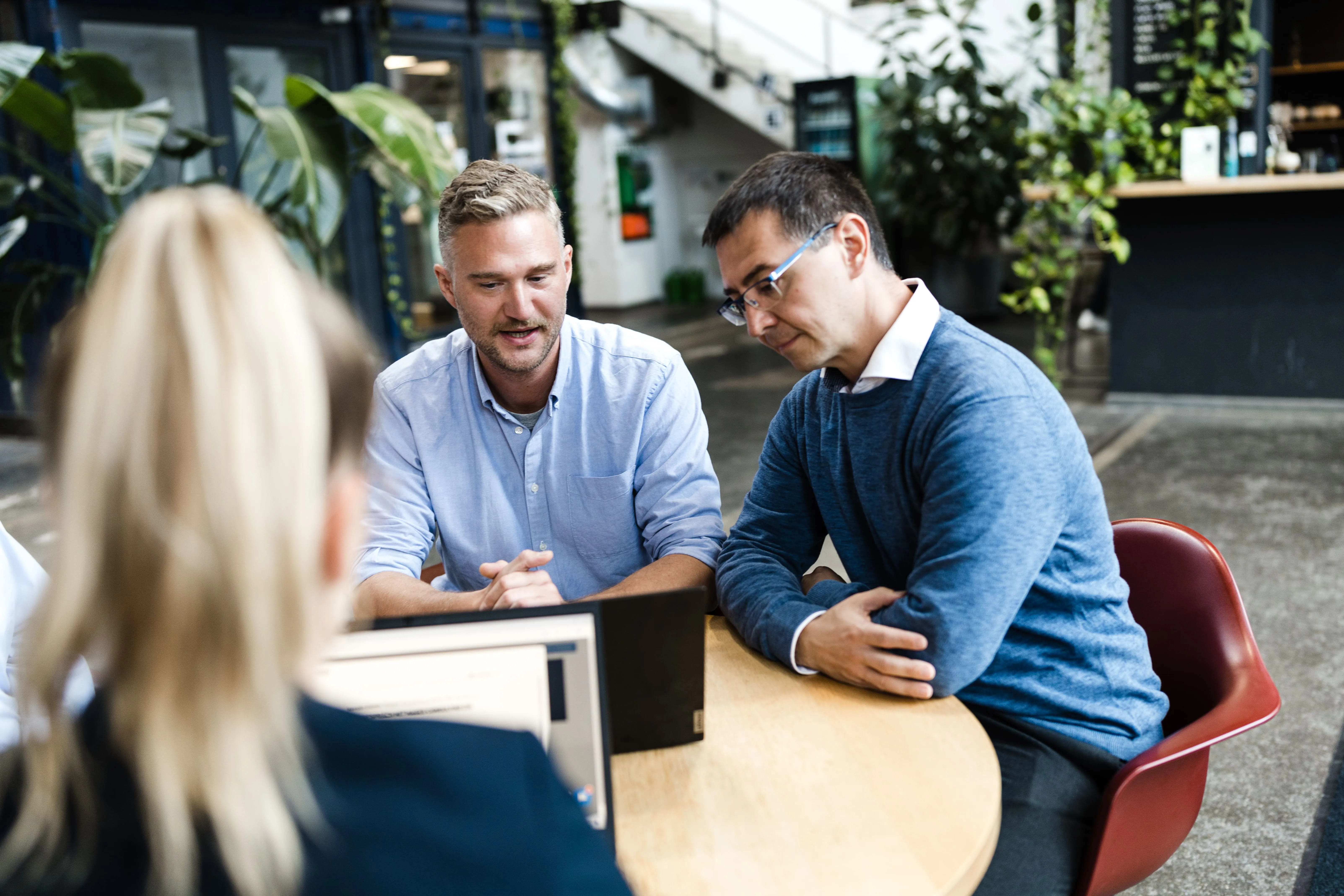 Mitarbeitende von Mages Consulting arbeiten gemeinsam am Tisch