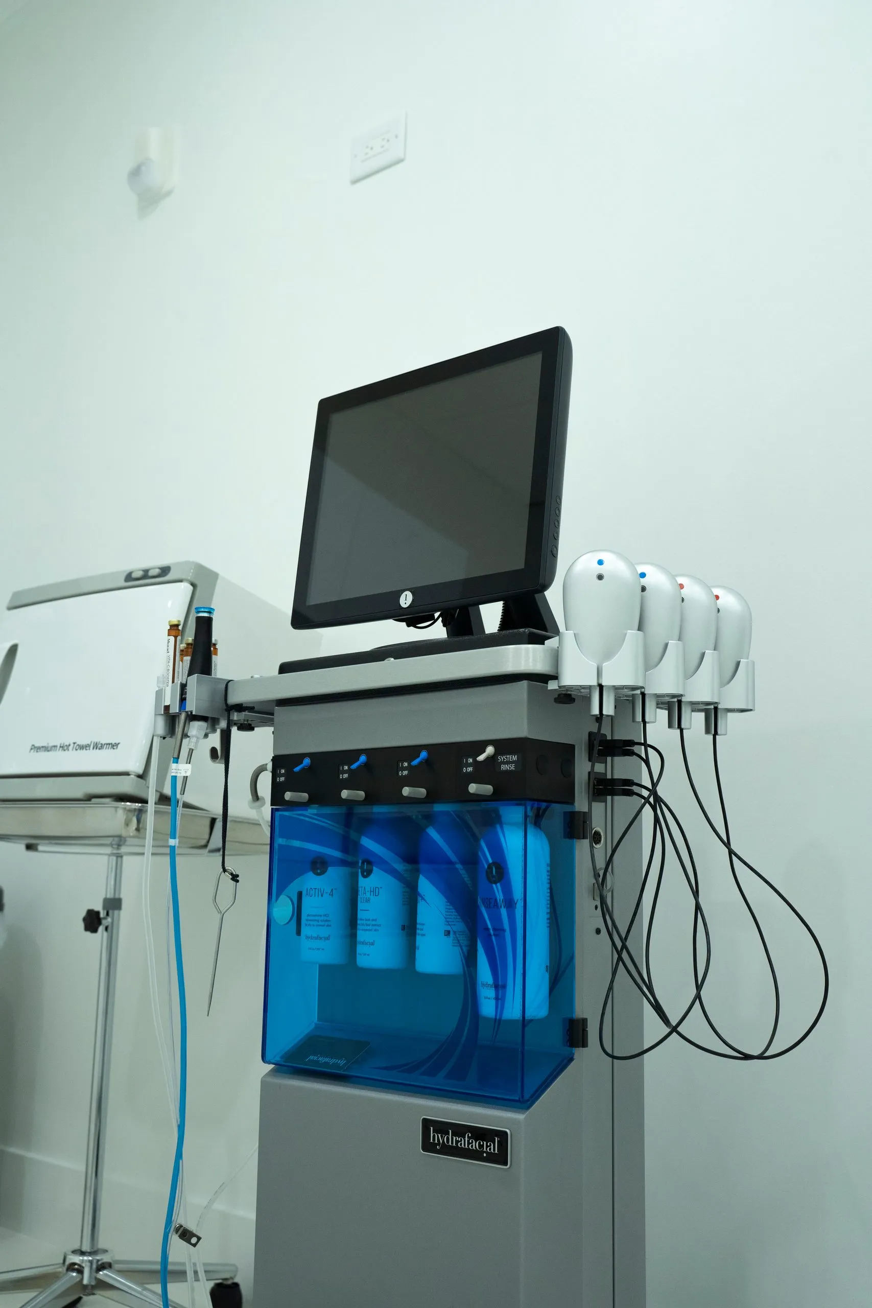 HydraFacial system with blue serum bottles and handpieces ready for treatment at Cosmetica Med Spa
