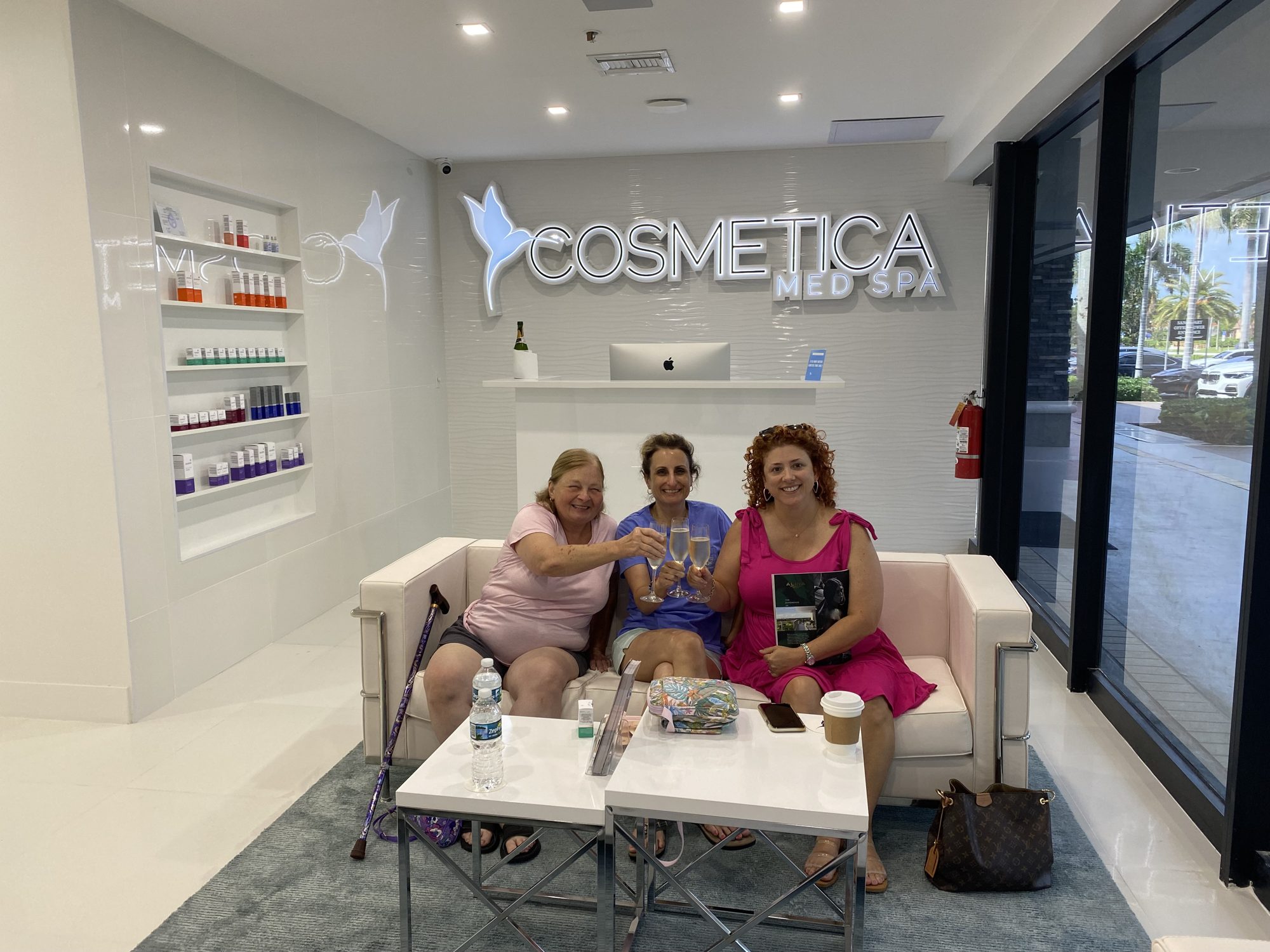 Happy clients toasting in the lobby of Cosmetica Med Spa in Boca Raton