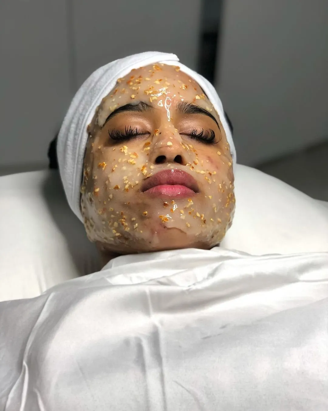 Client wearing a gold flake jelly mask during a facial at Cosmetica Med Spa
