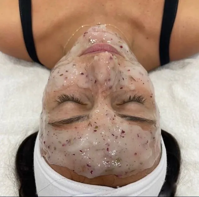 Client wearing a rose petal jelly mask during a facial at Cosmetica Med Spa