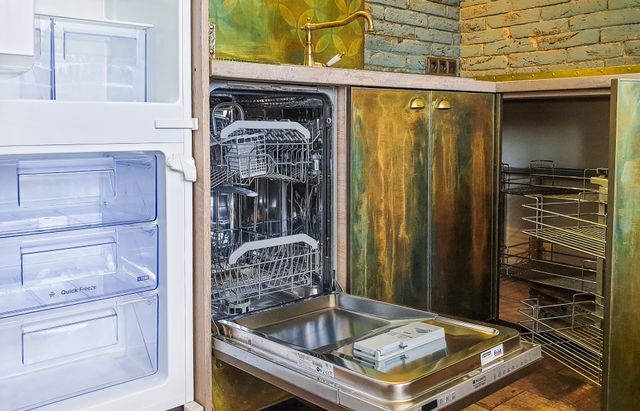 Открытая посудомоечная машина в кухонном мебельном ряду