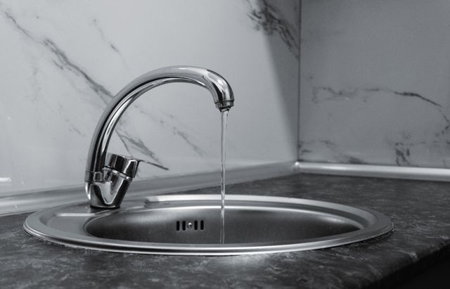 Хромированный кухонный смеситель с потоком воды